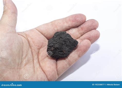 male hand   small piece  coal   light background royalty