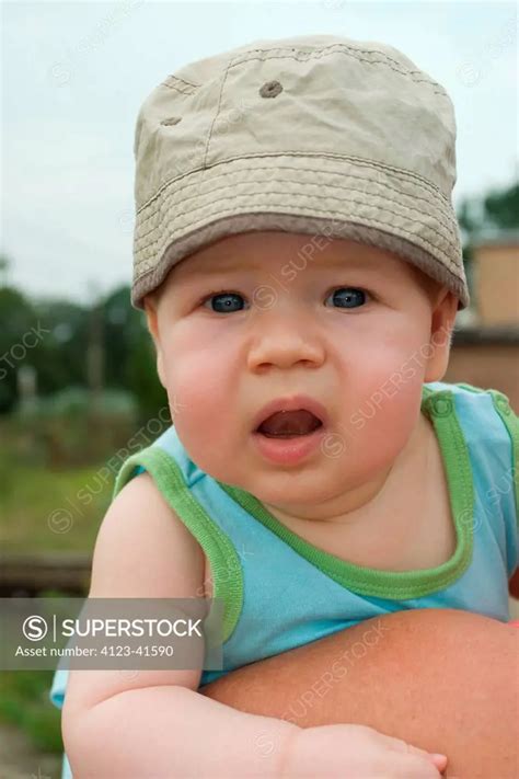 Baby being held by its parent. - SuperStock