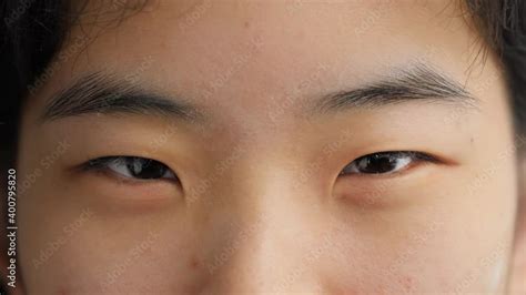 Face of cute and happy young Asian woman looking and winking at camera ...