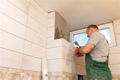 A Construction Worker Applies Cement Glue To the Wall To Glue the Next ...