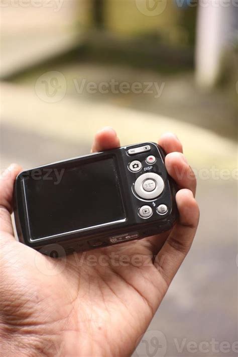 hand holding black pocket camera  stock photo  vecteezy