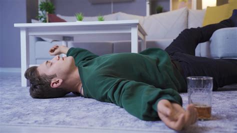 The hungover drunk man is sleeping on the floor. Drunk empty lifestyle