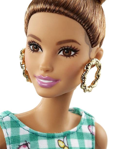 a close up of a barbie doll with big earrings