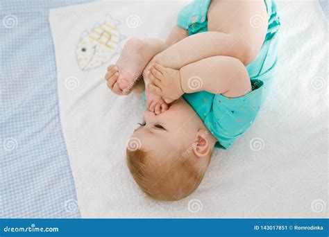 Милый младенец принимая ноги в рте Прелестный маленький всасывать ...