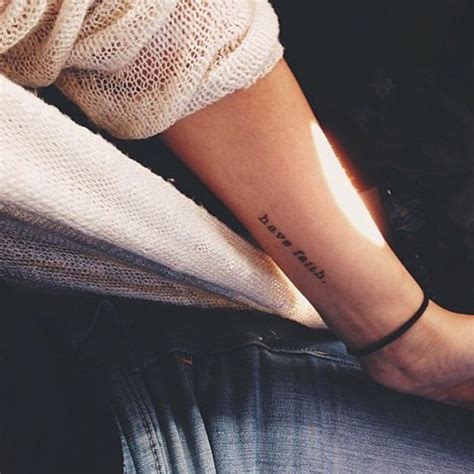 a person with a small tattoo on their arm and leg, sitting in a chair