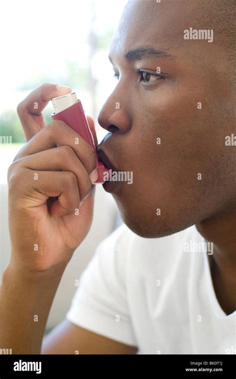 Man using an inhaler to treat an asthma attack Stock Photo - Alamy