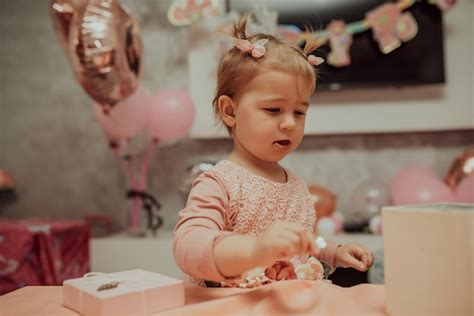 Menina de 2 anos de vestido rosa com seu primeiro bolo de aniversário ...