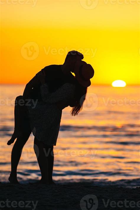 Romantic couple on the beach at colorful sunset on background 18044007 ...