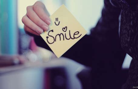 Фото Девушка держит бумажку с надписью *Smile*