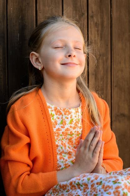 Premium Photo | Mindful girl with praying hands against wooden wall