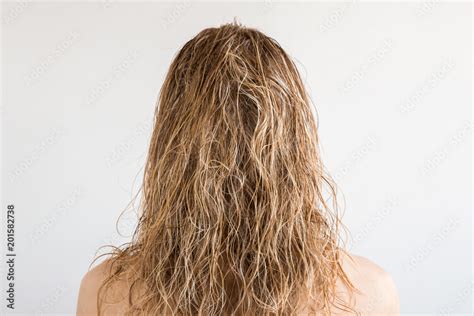 Wet, blonde, messy woman's hair after shower on the gray background ...