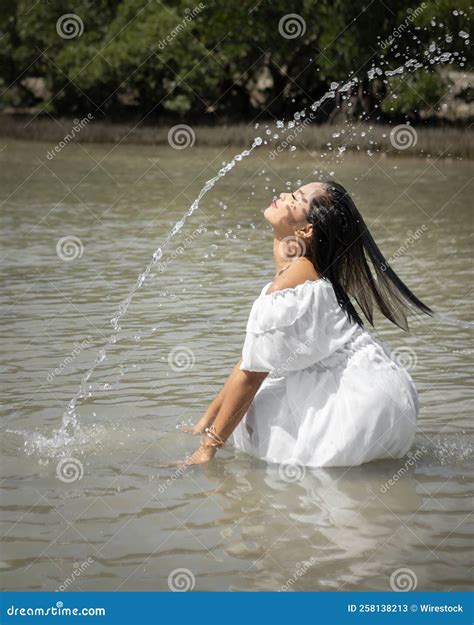 Southeast Asian Wet Girl in a White Dress Standing Barefoot in the