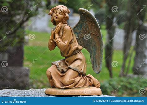 Bronze Statue Of An Angel Kneeling And Praying In A Cemetery Royalty ...