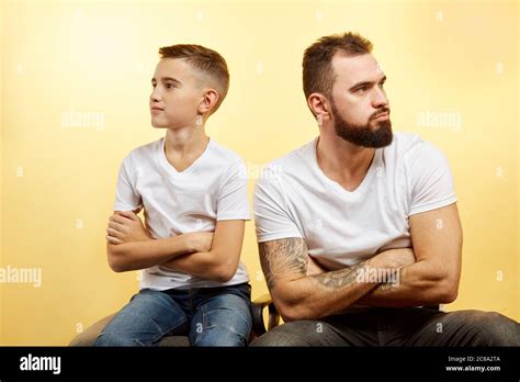 father  son sitting   yellow background