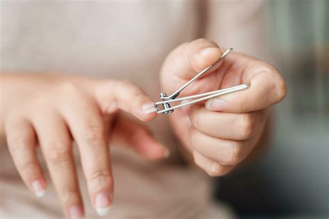 Woman cutting fingernails using nail clipper, Healthcare, Beauty