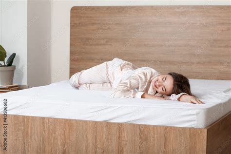 Morning of beautiful young woman lying on bed with soft mattress Stock