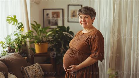 Southern european older pregnant woman in cozy living room with