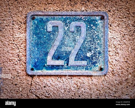 22, number twenty-two, old blue metal numeral plate on a wall Stock ...