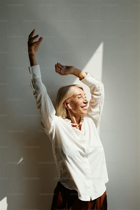 Back view portrait of elegant mature woman dancing lit by sunlight