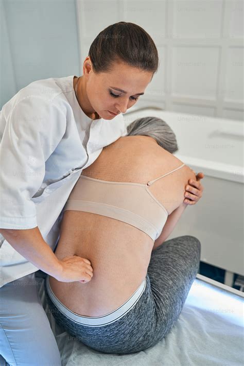 Serious therapist wearing uniform while working in modern clinic and