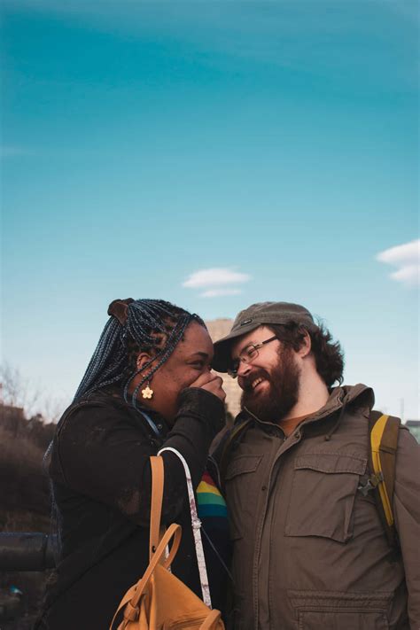 Download Interracial Couple Smiling Blue Skies Wallpaper | Wallpapers.com