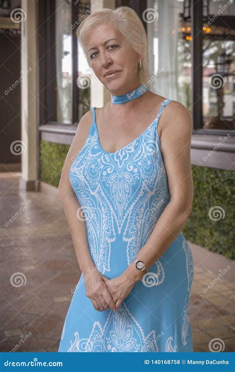 A Curvy Blond Mature Woman Smiles at the Camera with Big Beautiful Eyes