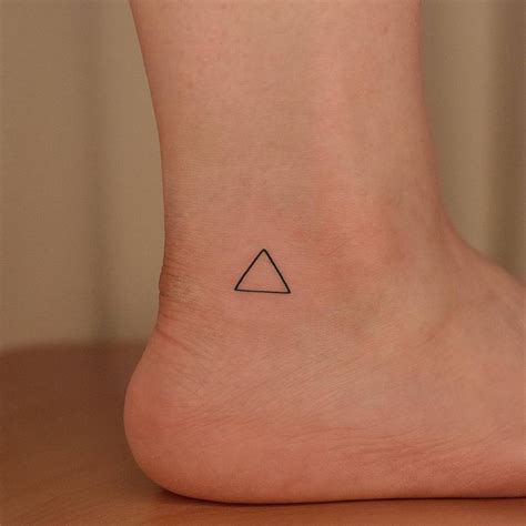 Fire alchemy symbol tattoo on the ankle