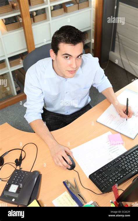 Young man working at an office desk Stock Photo - Alamy