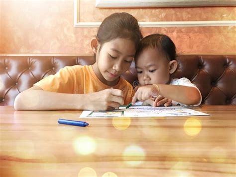 Sisters in Living Room Reading Book Stock Photo - Image of children ...