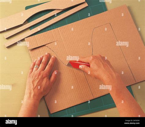 Cutting the corrugated cardboard with utility knife Stock Photo - Alamy