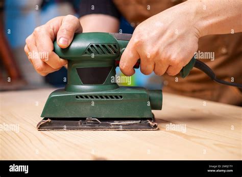 closeup  carpenter sanding wooden planks  electrical sanding