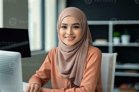 a Malay female employee sitting at her workplace in an office. AI