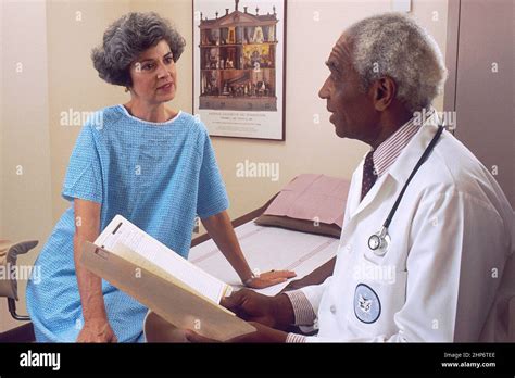 african american male doctor consults   adult female patient