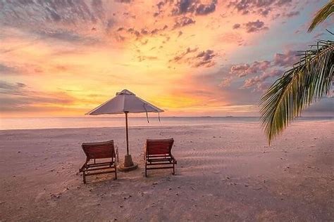 Amazing sunset beach. Romantic couple chairs umbrella