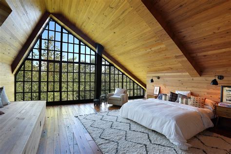 Spacious attic bedroom with a giant window under a vaulted ceiling
