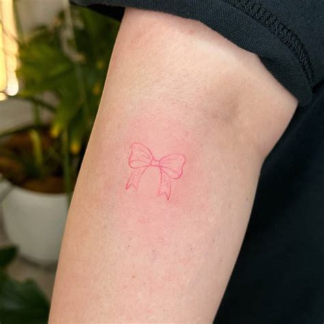 hand poked pink bow tattoo located   forearm