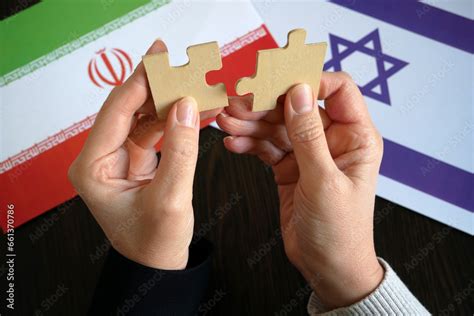 hands hold two pieces of a puzzle against the background of the flags ...
