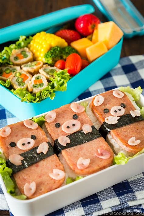 two trays filled with food on top of a blue and white table cloth next