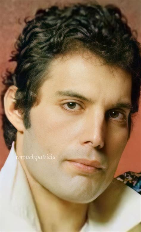 a man with curly hair wearing a white shirt and looking at the camera ...
