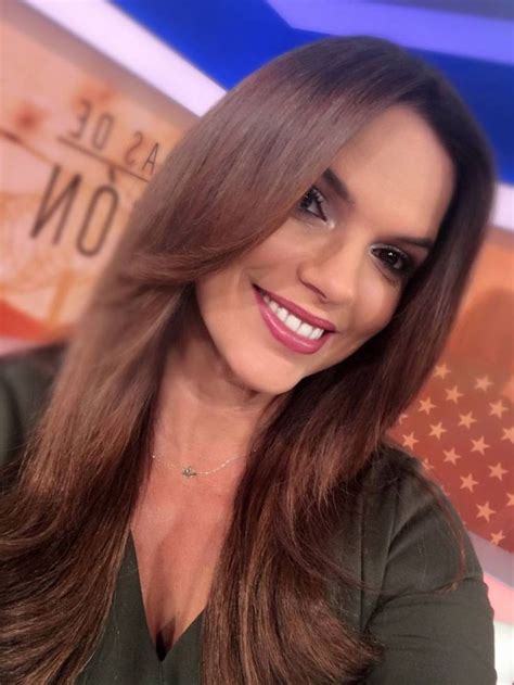 a woman with long brown hair and green shirt smiling at the camera in ...