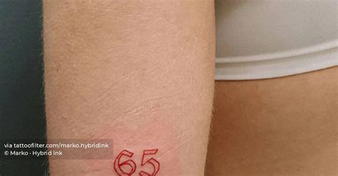 Tattoo of the number "65" located on the tricep, done