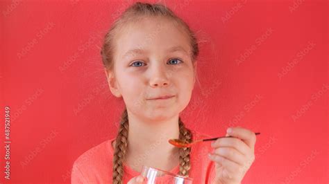 Child eating yogurt jelly pink background. Dairy product diet ...