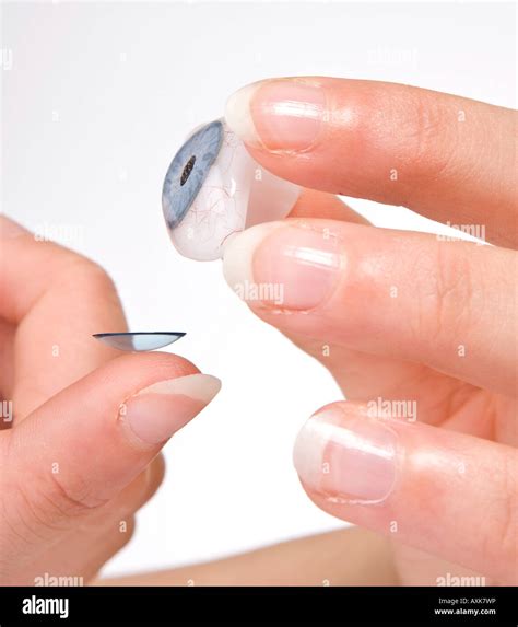 Hands putting a contact lens on a glass eye Stock Photo - Alamy