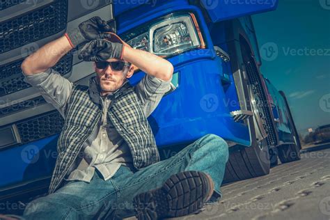 Male Trucker Sitting On Ground At Rest Stop Area. 24629871 Stock Photo