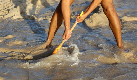 A Man Plays in the Sand with a Shovel on the Beach Near the Sea Stock ...