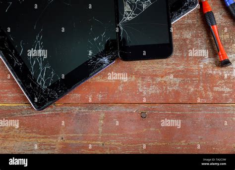 Repair tablet and smart phone with broken touch screen on wooden desk ...