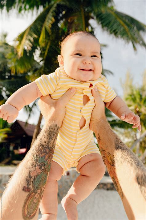 "Father Lifted The Baby To The Sky" by Stocksy Contributor "Andrey