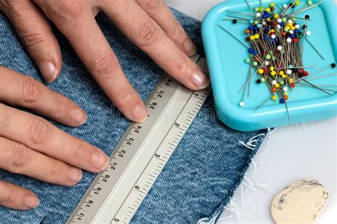 Two Hands Holding a Ruler in Place on Jeans Denim Material Stock Photo ...