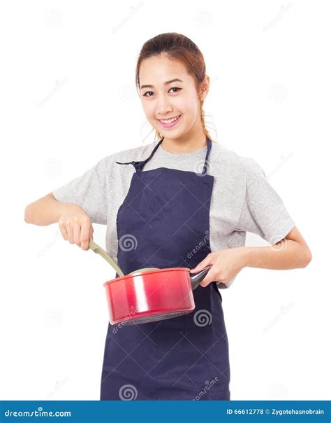Asian Woman Wearing Apron and Showing Pot with Utensil. Stock Photo