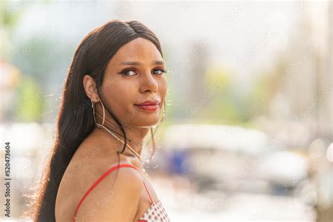 Transgender woman turning to look at the camera outdoors Stock Photo ...